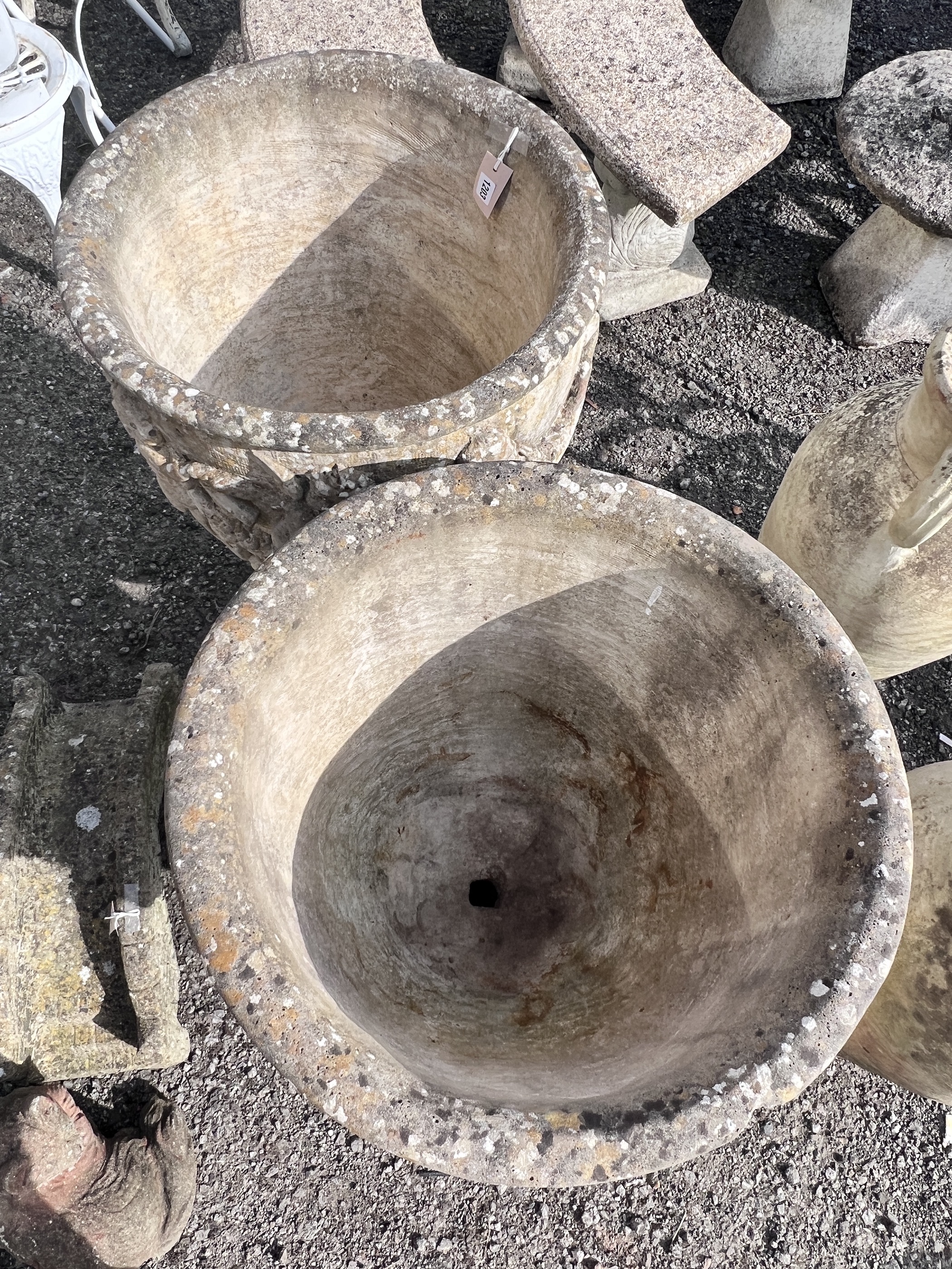A pair of large circular reconstituted stone garden planters, moulded with a band of putti on square bases, diameter 53cm, height 89cm